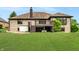 Back exterior view of brick home with back deck overlooking green lawn at 7665 Stones River Ct, Indianapolis, IN 46259