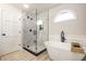 Modern bathroom showcasing a walk-in shower, soaking tub, and an arched window at 7665 Stones River Ct, Indianapolis, IN 46259