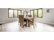 Light-filled dining room with wooden table, stylish woven chairs, and large windows at 7665 Stones River Ct, Indianapolis, IN 46259