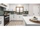 Bright kitchen features stainless steel appliances, white cabinets and countertops, and stylish backsplash at 7665 Stones River Ct, Indianapolis, IN 46259
