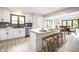 Open kitchen view with an island, wood stools, white countertops, and dining room with wood table at 7665 Stones River Ct, Indianapolis, IN 46259