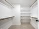 Bright walk-in closet featuring custom shelves and wood-grain floor at 7665 Stones River Ct, Indianapolis, IN 46259