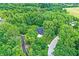 Aerial view of a dark roof home secluded in the trees with a long driveway and a large yard at 7716 Traders Hollow Ln, Indianapolis, IN 46278