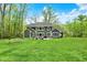 Beautiful backyard with a well-maintained lawn, patio furniture, and surrounded by mature trees at 7716 Traders Hollow Ln, Indianapolis, IN 46278