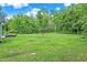 Expansive backyard with lush green grass and mature trees offering privacy at 7716 Traders Hollow Ln, Indianapolis, IN 46278