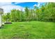 Large grassy backyard bordered by trees, creating a peaceful and spacious setting at 7716 Traders Hollow Ln, Indianapolis, IN 46278
