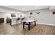 Finished basement with luxury vinyl plank flooring and wet bar area with pub-style seating and air hockey table at 7716 Traders Hollow Ln, Indianapolis, IN 46278