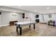 Finished basement with luxury vinyl plank flooring, entertaining area with sectional and air hockey table at 7716 Traders Hollow Ln, Indianapolis, IN 46278