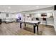 Finished basement with luxury vinyl plank flooring, wet bar, and entertainment area with air hockey table at 7716 Traders Hollow Ln, Indianapolis, IN 46278