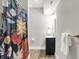 Well-lit bathroom featuring modern vanity with storage and decorative patterned shower curtain at 7716 Traders Hollow Ln, Indianapolis, IN 46278
