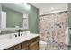 Charming bathroom with a wood vanity, framed mirror, and shower with floral curtain for a relaxing aesthetic at 7716 Traders Hollow Ln, Indianapolis, IN 46278