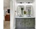 Modern bathroom with a gray vanity, double sinks, marble countertop, and decorative tulip floral arrangement at 7716 Traders Hollow Ln, Indianapolis, IN 46278