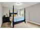 Cozy bedroom featuring a dark wood four-poster bed, side table, and a window with natural light at 7716 Traders Hollow Ln, Indianapolis, IN 46278
