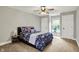 Inviting bedroom with a comfortable bed, ceiling fan, neutral walls, and bright natural light from the window at 7716 Traders Hollow Ln, Indianapolis, IN 46278