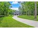 A long driveway that leads to a two-story home with an attached garage, surrounded by green trees at 7716 Traders Hollow Ln, Indianapolis, IN 46278
