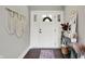 Bright entryway featuring a white door with glass panels, decorative mirror and macrame wall hanging at 7716 Traders Hollow Ln, Indianapolis, IN 46278