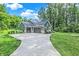 Charming green home with a two car garage, long driveway and lush landscaping at 7716 Traders Hollow Ln, Indianapolis, IN 46278