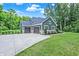 Beautifully landscaped green home featuring an attached two car garage and blue skies at 7716 Traders Hollow Ln, Indianapolis, IN 46278