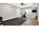 Finished home gym with exercise equipment, TV, rubber flooring, and natural light from the window at 7716 Traders Hollow Ln, Indianapolis, IN 46278