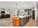 Open kitchen with island, stainless appliances, and hardwood floors at 7716 Traders Hollow Ln, Indianapolis, IN 46278