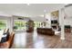Open-concept living room with hardwood floors, a stone fireplace, and large windows at 7716 Traders Hollow Ln, Indianapolis, IN 46278