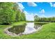 Picturesque pond framed by lush greenery, creating a peaceful and natural ambiance at 7716 Traders Hollow Ln, Indianapolis, IN 46278