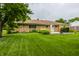 A sprawling backyard with a well-maintained lawn and a brick home at 8103 Rumford Rd, Indianapolis, IN 46219