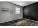 Neutral bedroom featuring wood-look floors, accent wall, and plenty of natural light at 8103 Rumford Rd, Indianapolis, IN 46219