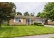 Beautiful brick home featuring a large lawn, mature trees, and an attached two-car garage with basketball hoop at 8103 Rumford Rd, Indianapolis, IN 46219