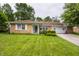 Charming brick home featuring a well-manicured lawn, flower beds, and attached two-car garage with basketball hoop at 8103 Rumford Rd, Indianapolis, IN 46219