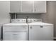 Laundry room showcasing a white washer and dryer, with upper storage cabinets at 8103 Rumford Rd, Indianapolis, IN 46219
