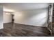 Spacious living room with dark hardwood floors, light-colored walls, and a chandelier in the adjacent dining area at 8103 Rumford Rd, Indianapolis, IN 46219
