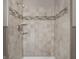 Updated shower with tiled walls, a decorative tile accent, and a modern shower head at 8103 Rumford Rd, Indianapolis, IN 46219