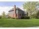 Exterior shot of a backyard featuring a brick chimney and a lush green lawn at 839 Pebble Brook Pl, Noblesville, IN 46062