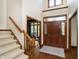 Inviting foyer with a wood door, hardwood floors, a staircase, and lots of natural light at 839 Pebble Brook Pl, Noblesville, IN 46062