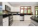 Well-equipped kitchen with stainless steel appliances, tile backsplash, and wood trim windows at 839 Pebble Brook Pl, Noblesville, IN 46062