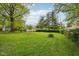 Large, green backyard with mature trees provides a peaceful outdoor space and room for recreation at 944 N Harbison Ave, Indianapolis, IN 46219