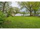 Spacious backyard featuring lush green grass, mature trees, and a swing set, great for outdoor activities at 944 N Harbison Ave, Indianapolis, IN 46219