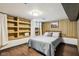 Basement bedroom with hardwood floors, built-in shelving, and wood paneling at 944 N Harbison Ave, Indianapolis, IN 46219