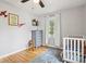 Bright Bedroom features hardwood floors, area rug, and a white crib at 944 N Harbison Ave, Indianapolis, IN 46219