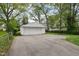 Detached garage with a long driveway and a well-maintained lawn and landscaping at 944 N Harbison Ave, Indianapolis, IN 46219