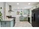 Updated kitchen featuring stainless steel appliances, quartz countertops, and stylish green cabinets at 944 N Harbison Ave, Indianapolis, IN 46219