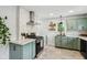 Charming kitchen featuring light green cabinets, tile backsplash, and stainless steel appliances at 944 N Harbison Ave, Indianapolis, IN 46219