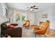 Bright living room featuring hardwood floors, a ceiling fan, and a large window with natural light at 944 N Harbison Ave, Indianapolis, IN 46219