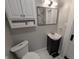 A cozy bathroom featuring a toilet, vanity with sink, and a mirror above the sink at 1009 Chestnut St, Anderson, IN 46012
