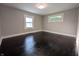 Inviting bedroom featuring dark wood floors, neutral paint, and plenty of natural light from two windows at 1009 Chestnut St, Anderson, IN 46012