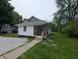 Side view of a cozy, single-story house featuring gravel and a landscaped lawn at 1009 Chestnut St, Anderson, IN 46012