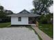 Charming single-story home featuring a gravel front yard and a cozy, covered entrance with brick columns at 1009 Chestnut St, Anderson, IN 46012