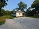 A quaint single-story home with gravel front yard surrounded by lush greenery on a clear day at 1009 Chestnut St, Anderson, IN 46012
