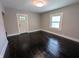 Bright living room showcasing dark wood floors, fresh paint, and natural light streaming through a window at 1009 Chestnut St, Anderson, IN 46012